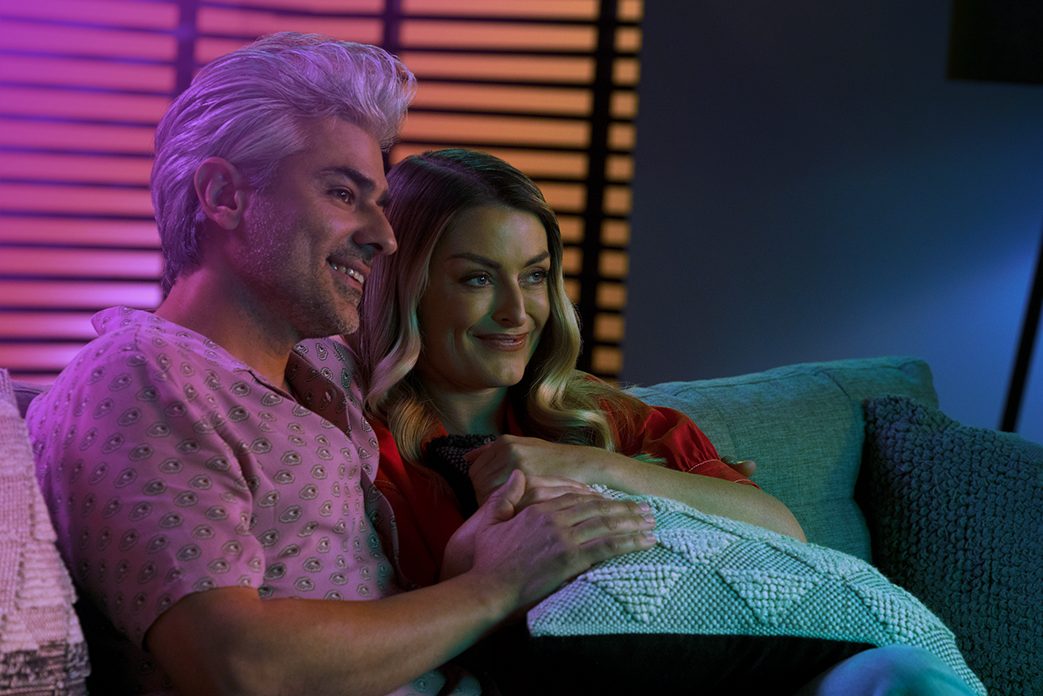 Image of a couple on a couch watch TV together